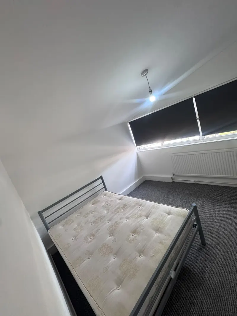 Bed and carpet beside the bedroom window
