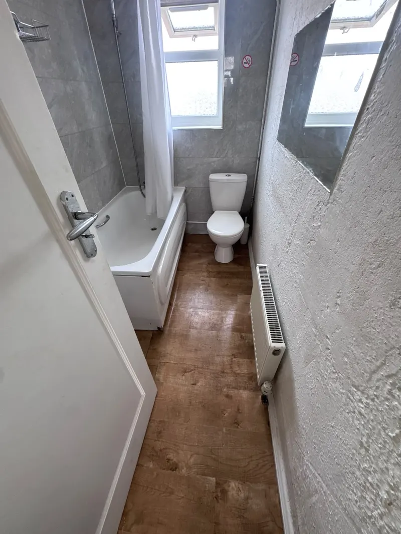 Bathroom with bath, toilet and wood-effect flooring